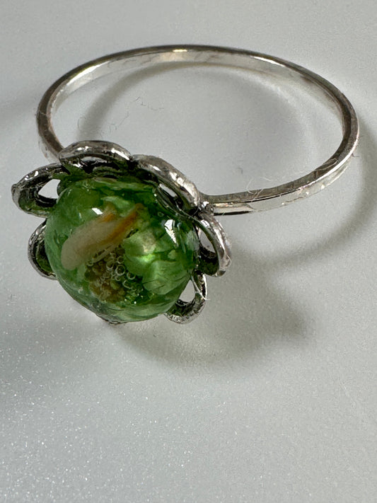 Flower Ring Encased in Green Resin and pink flowers.