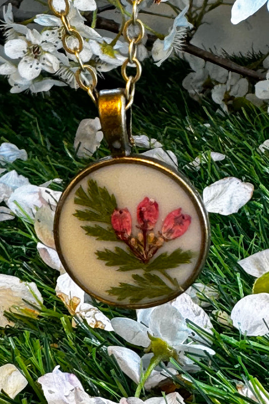 Dainty Round Pendant with Red Flowers on a White Background
