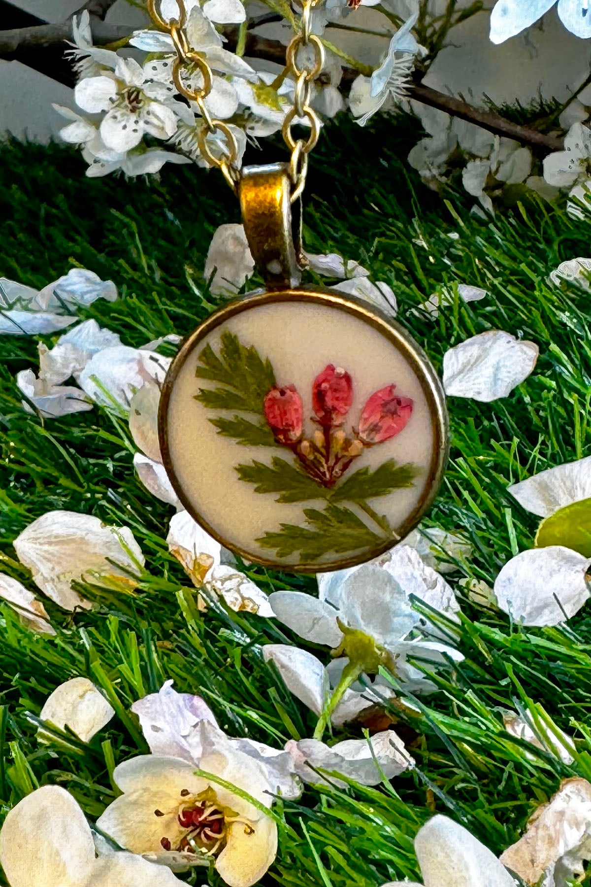 Dainty Round Pendant with Red Flowers on a White Background